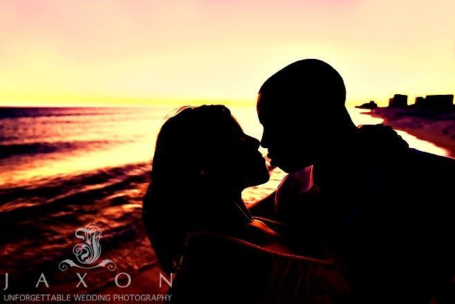Silhouetted Sunset engagement photo of couple kissing