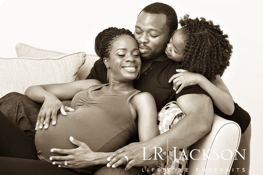 Husband, daughter and expecting mother in family portrait, sepia toned image of African American Family