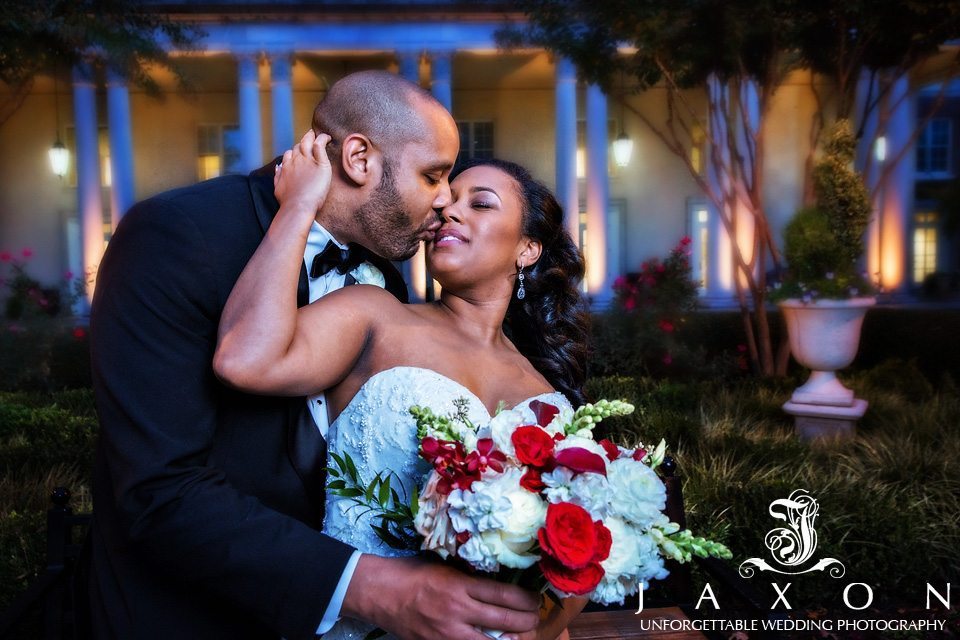 Newly wed locked in romantic embrace in the gardens at Atlanta Biltmore Ballrooms at twilight