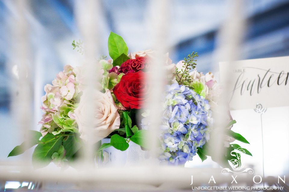 Photo of floral arrangement looking thru the rails of a white chair