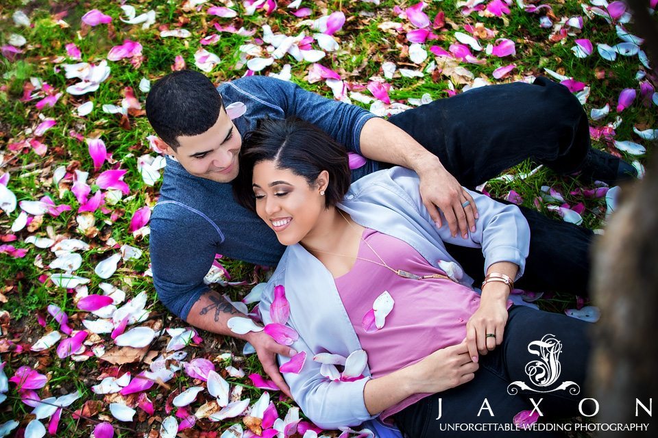 Couple on the grass surrounded by the brilliant goblet like blooms of the magnolia tree